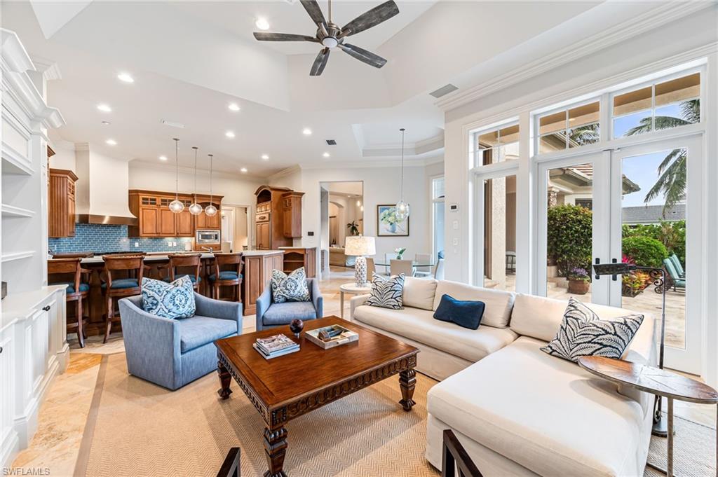 Living room featuring a tray ceiling, ceiling fan, and ornamental molding
