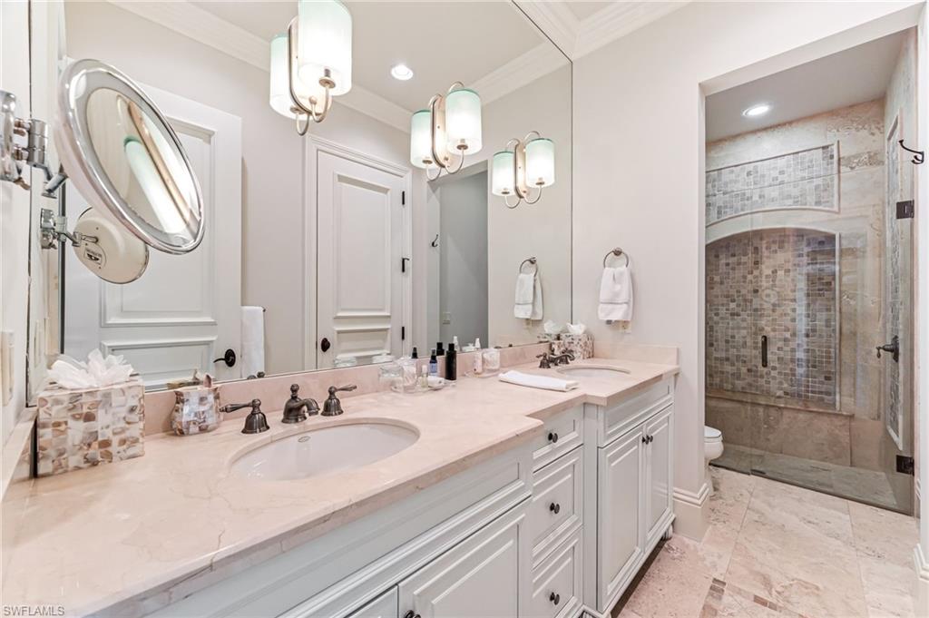 Bathroom featuring vanity, toilet, an enclosed shower, and ornamental molding