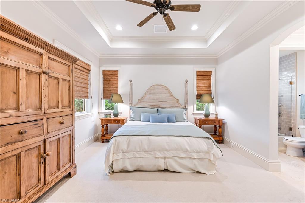 Bedroom featuring ensuite bath, ceiling fan, light colored carpet, and ornamental molding
