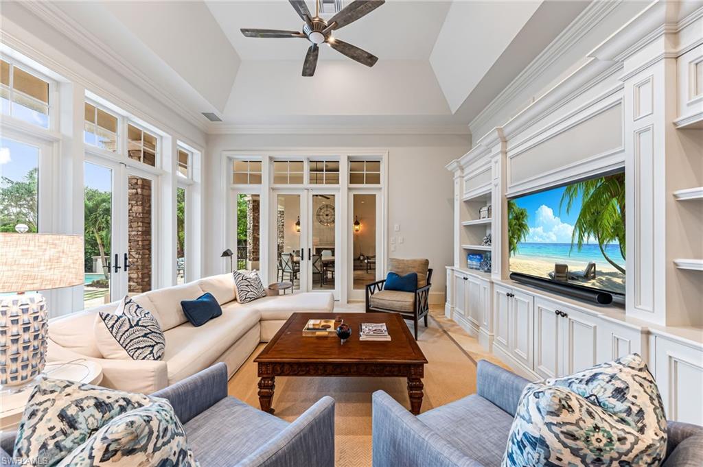 Carpeted living room with french doors, ornamental molding, and a tray ceiling
