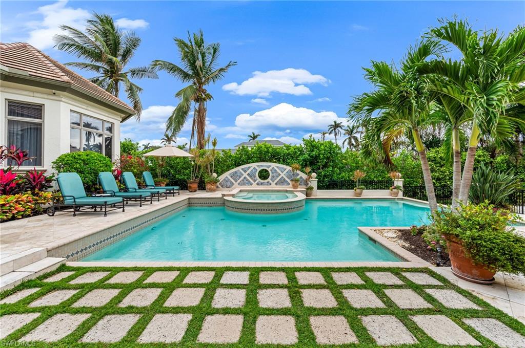 View of pool with an in ground hot tub and a patio