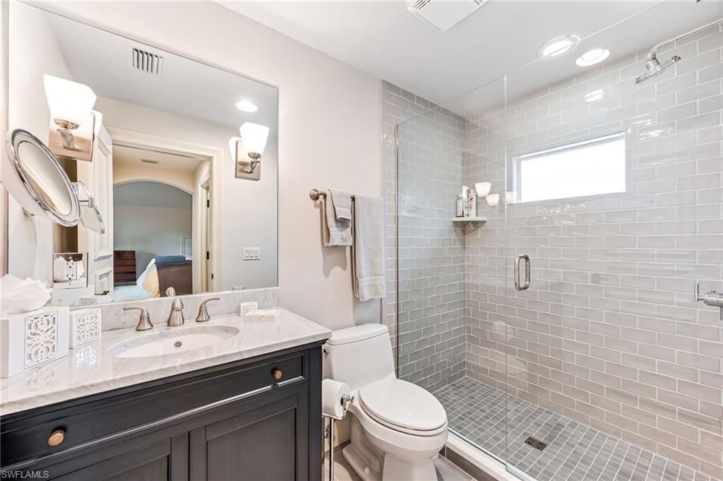Bathroom with vanity, toilet, and an enclosed shower