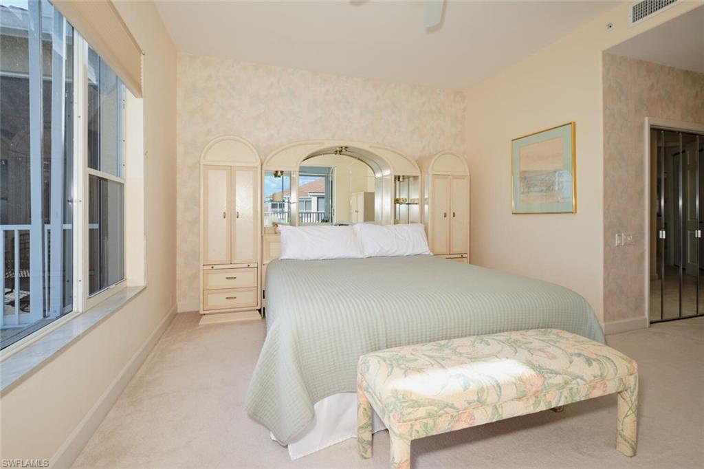 Bedroom with ceiling fan and light carpet