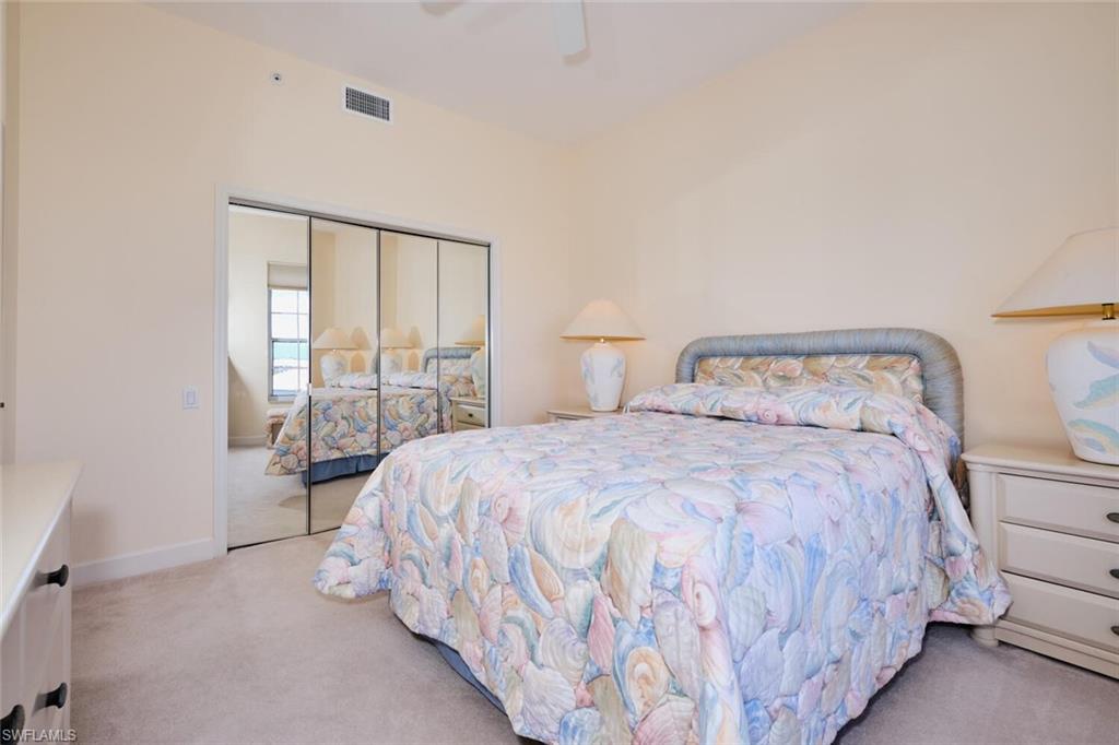 Carpeted bedroom with ceiling fan and a closet