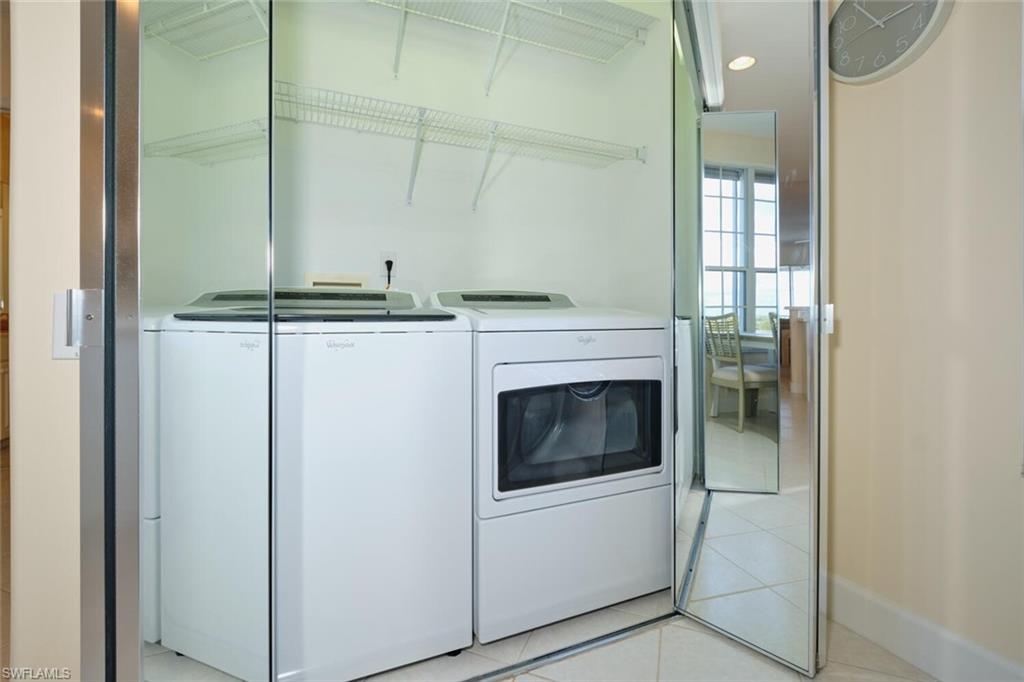 Laundry area featuring washing machine and dryer and light tile patterned floors