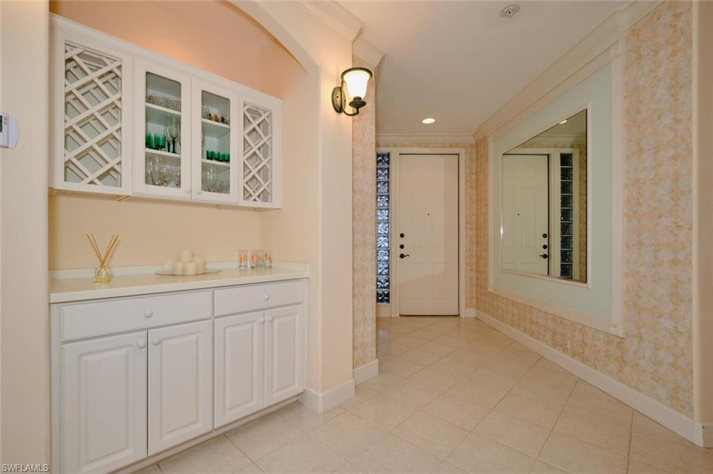 Hall with light tile patterned floors and ornamental molding