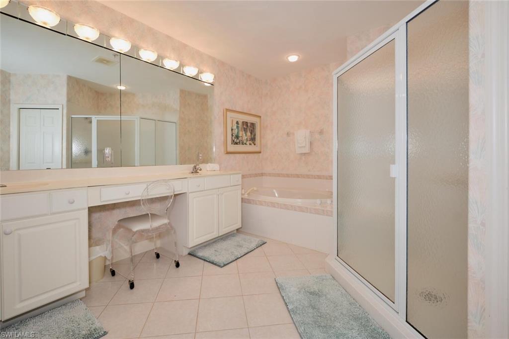 Bathroom featuring vanity, plus walk in shower, and tile patterned flooring