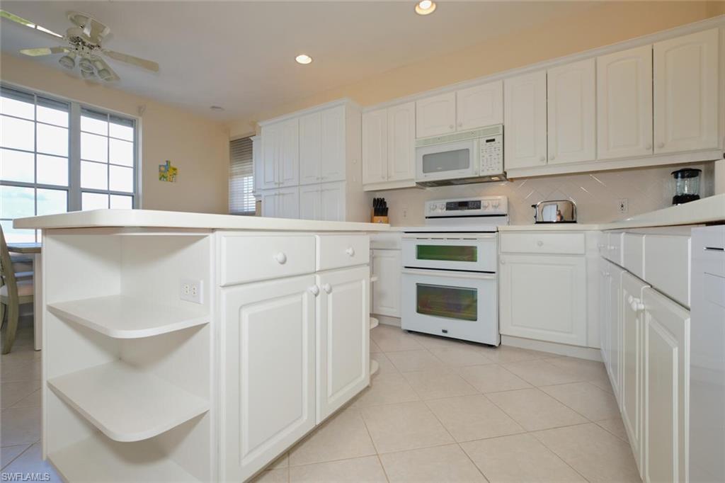 Kitchen featuring white cabinetry and white appliances