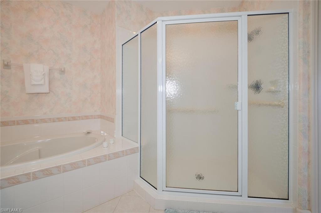 Bathroom featuring tile patterned floors and plus walk in shower