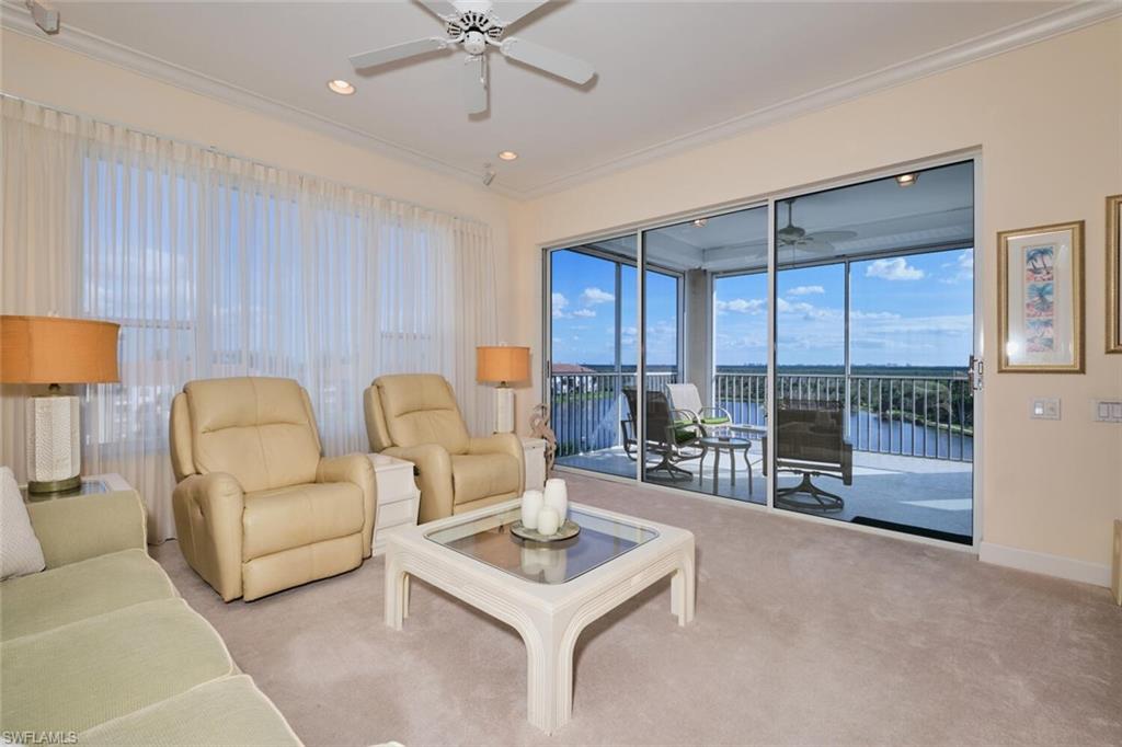 Living room with ceiling fan, a water view, light carpet, and ornamental molding
