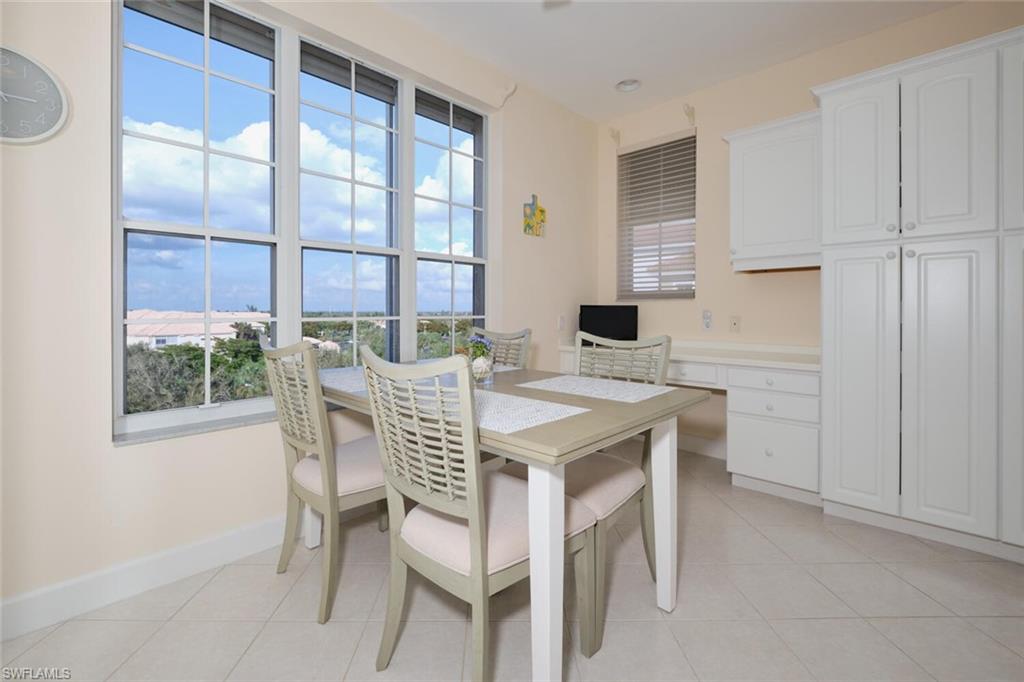 Dining space with a wealth of natural light, built in desk, and light tile patterned floors