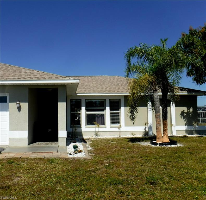 Property entrance with a garage and a yard