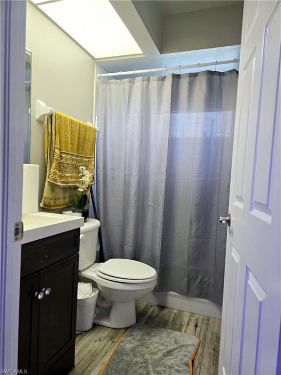 2nd Bathroom with tub, tile walls, and plank style tile flooring.