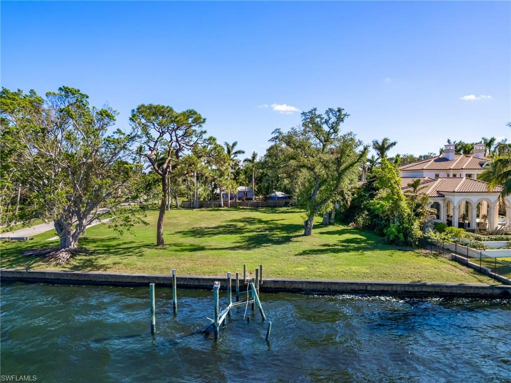 Dock area with a lawn and a water view