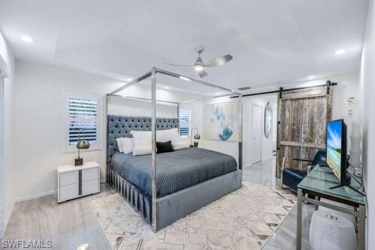 Bedroom featuring a barn door and ceiling fan