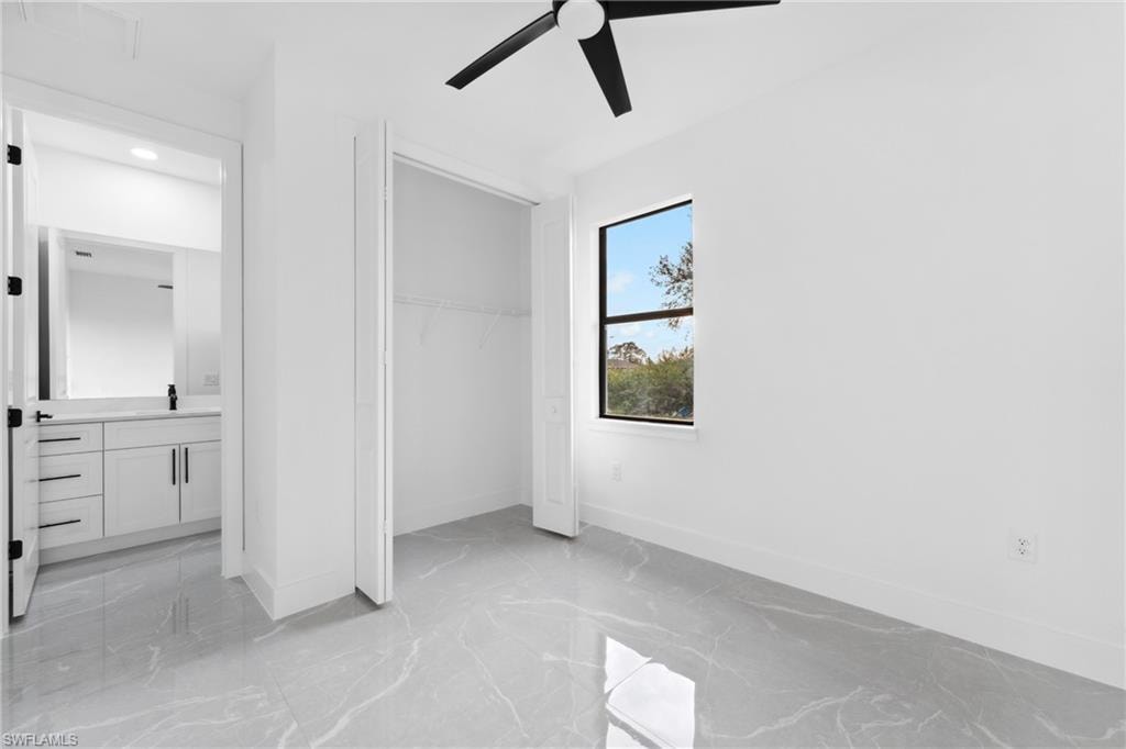 Unfurnished bedroom with ceiling fan and a closet