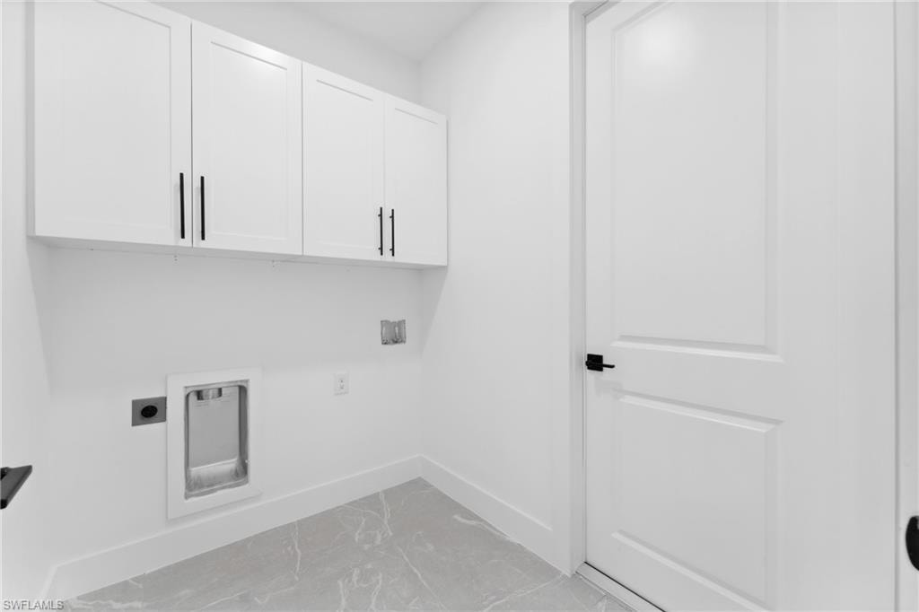 Laundry room with hookup for an electric dryer, cabinets, and washer hookup