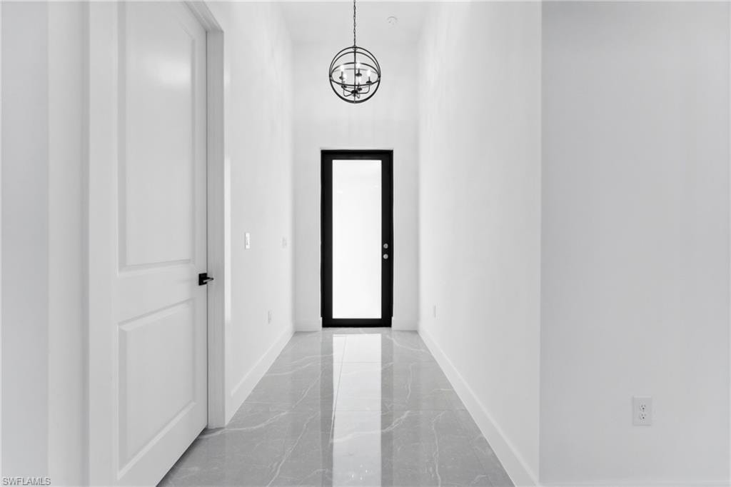 Corridor featuring an inviting chandelier