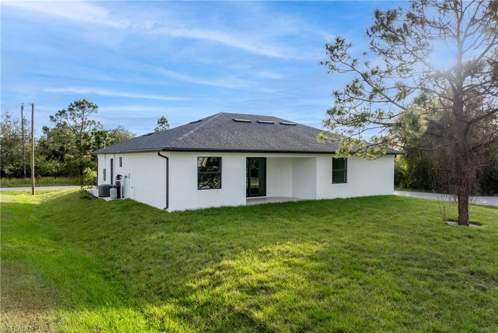 Back of house with a yard and a patio area