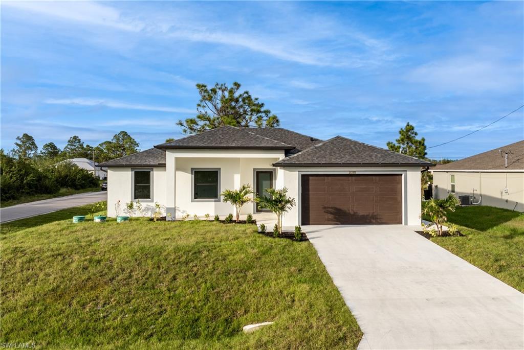 View of front of property featuring a front yard and a garage
