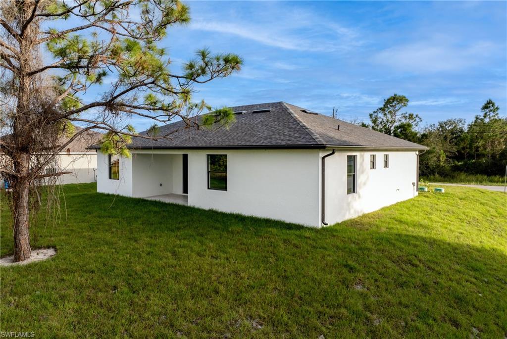 Rear view of house with a yard and a patio