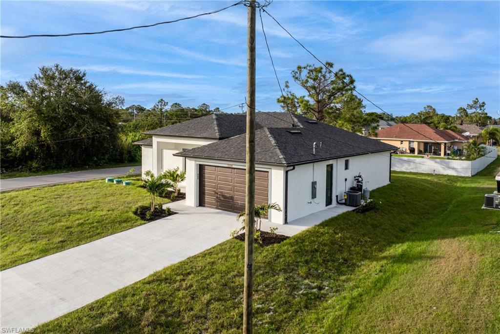 View of property exterior with central air condition unit and a lawn