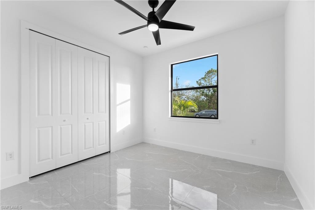 Unfurnished bedroom with ceiling fan and a closet