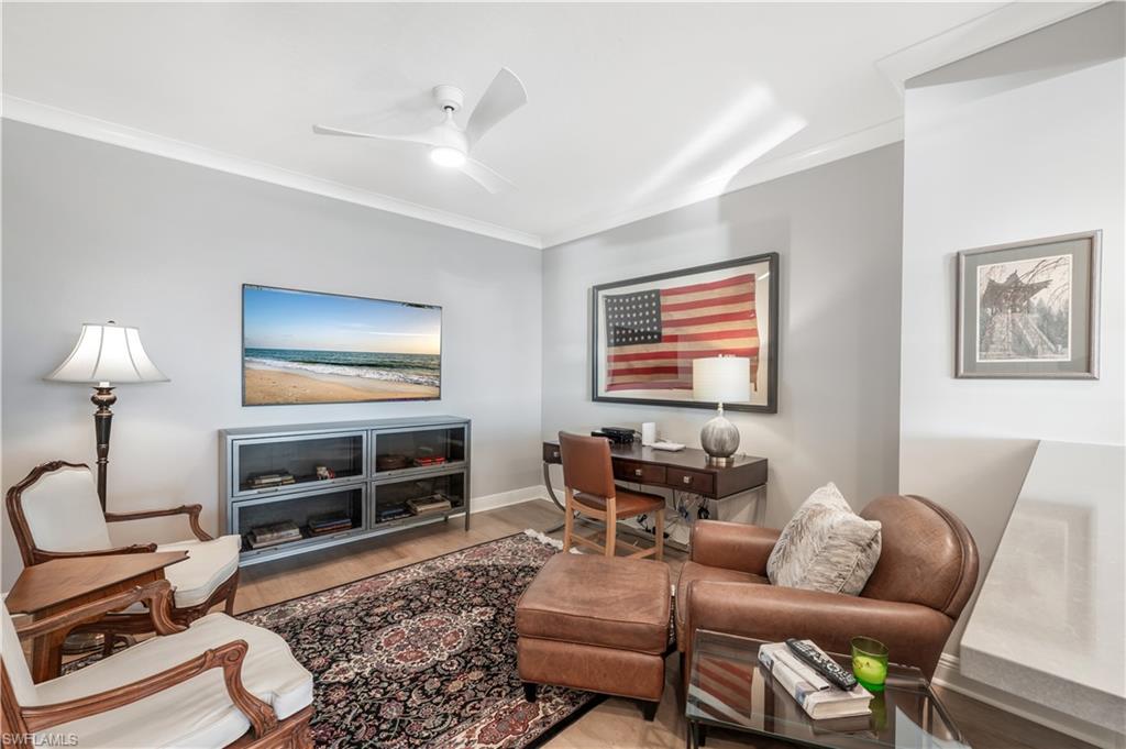 Living room featuring light hardwood / wood-style floors, ceiling fan, and ornamental molding