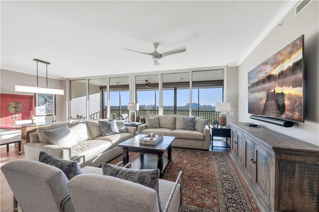 Living room featuring wood-type flooring, plenty of natural light, crown molding, and ceiling fan