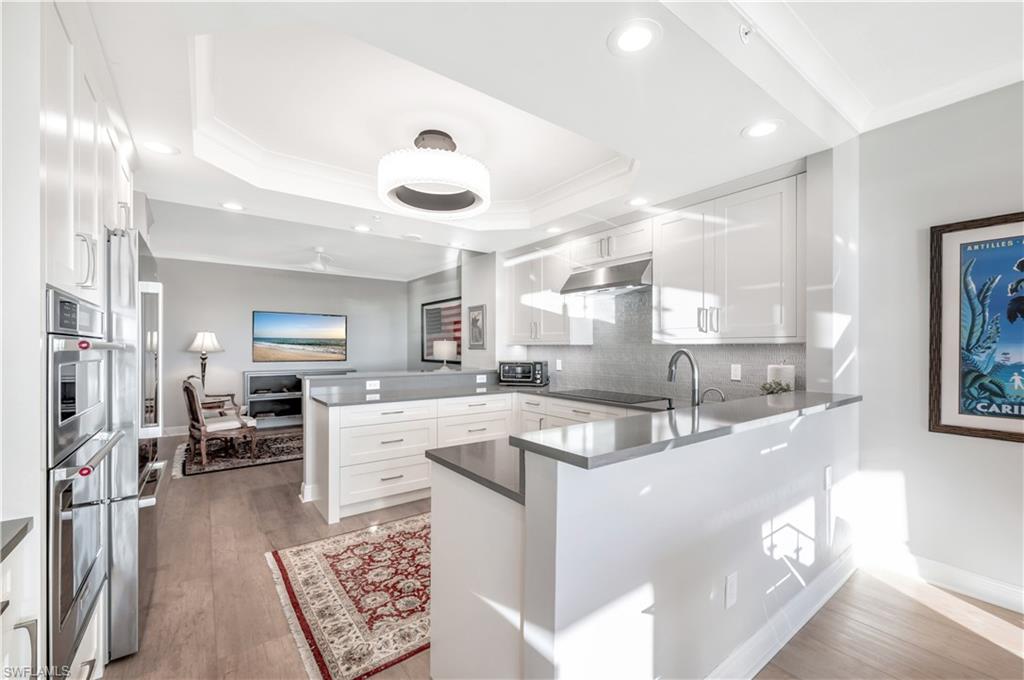 Kitchen featuring hardwood / wood-style floors, white cabinetry, and kitchen peninsula