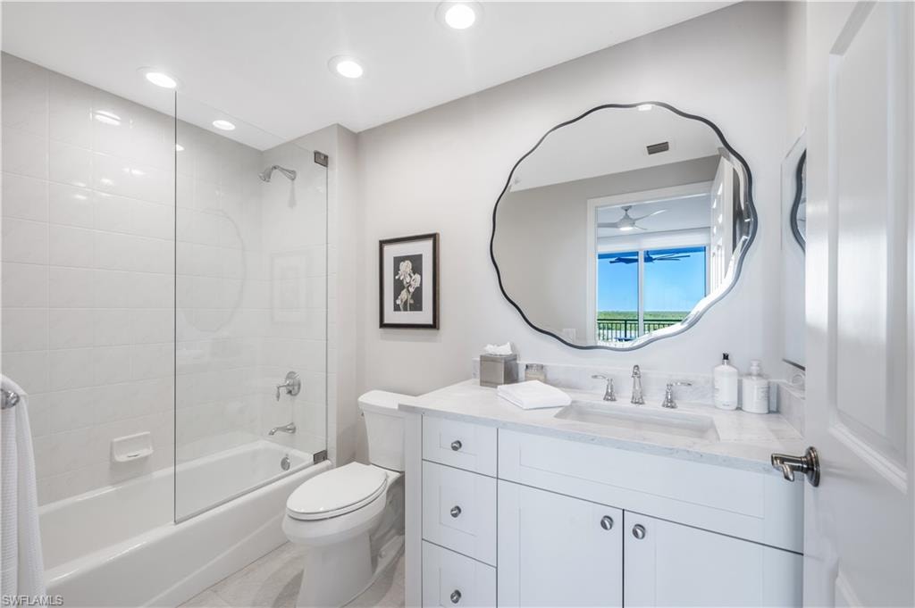 Full bathroom featuring tiled shower / bath combo, toilet, and vanity