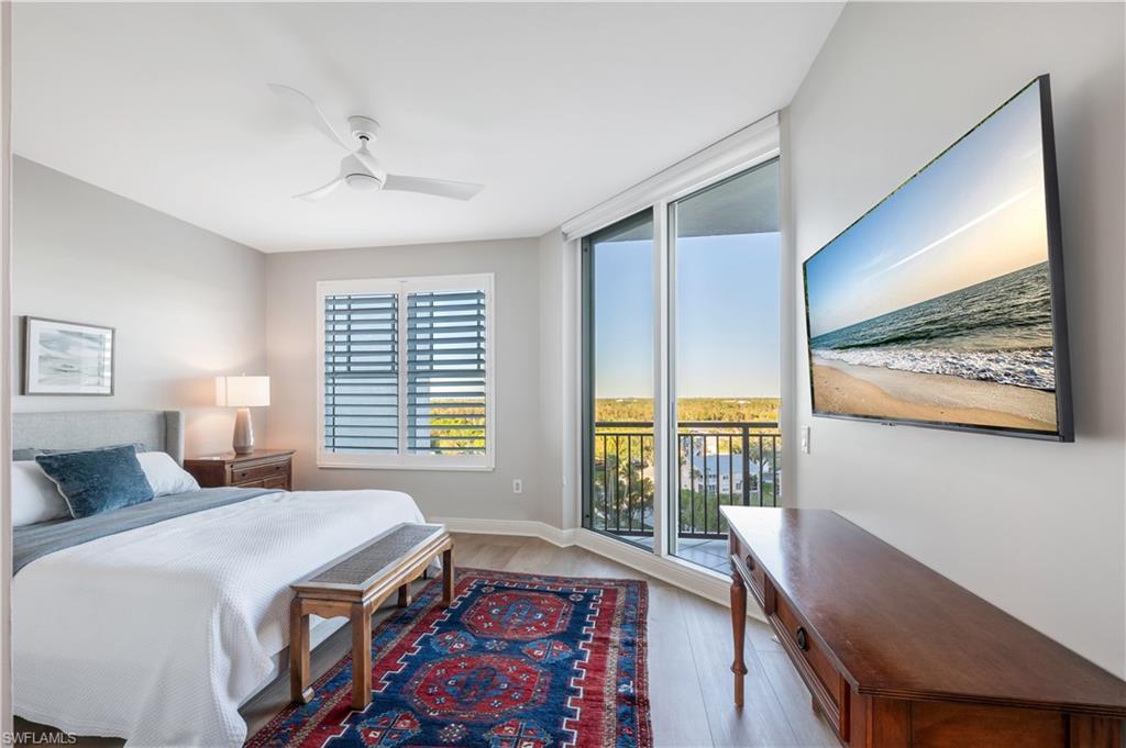 Bedroom with access to outside, multiple windows, light hardwood / wood-style floors, and ceiling fan