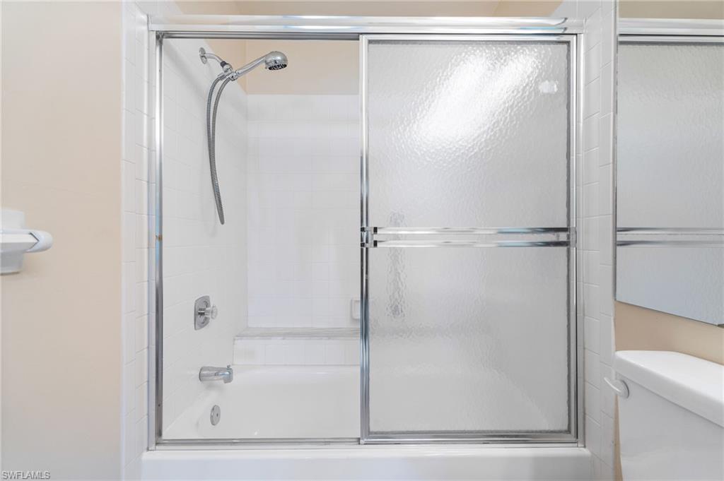 Bathroom featuring toilet and enclosed tub / shower combo