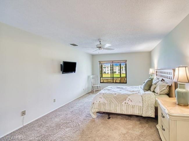 Bedroom featuring carpet, a textured ceiling, and a ceiling fan