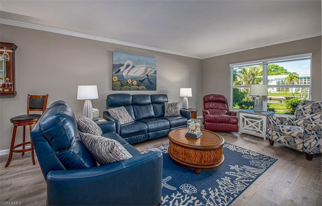 Living room featuring hardwood / wood-style flooring and crown molding