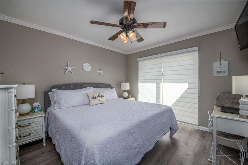 Bedroom featuring ceiling fan, dark hardwood / wood-style floors, and ornamental molding