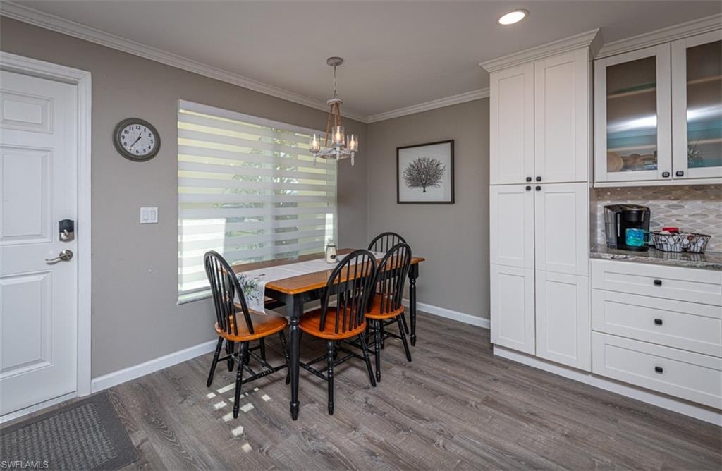 Dining space featuring hardwood / wood-style floors, a chandelier, and ornamental molding