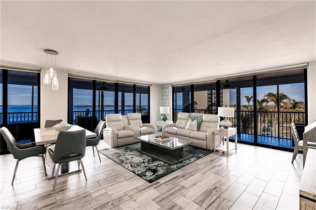 Living room featuring a water view, expansive windows, and ceiling fan