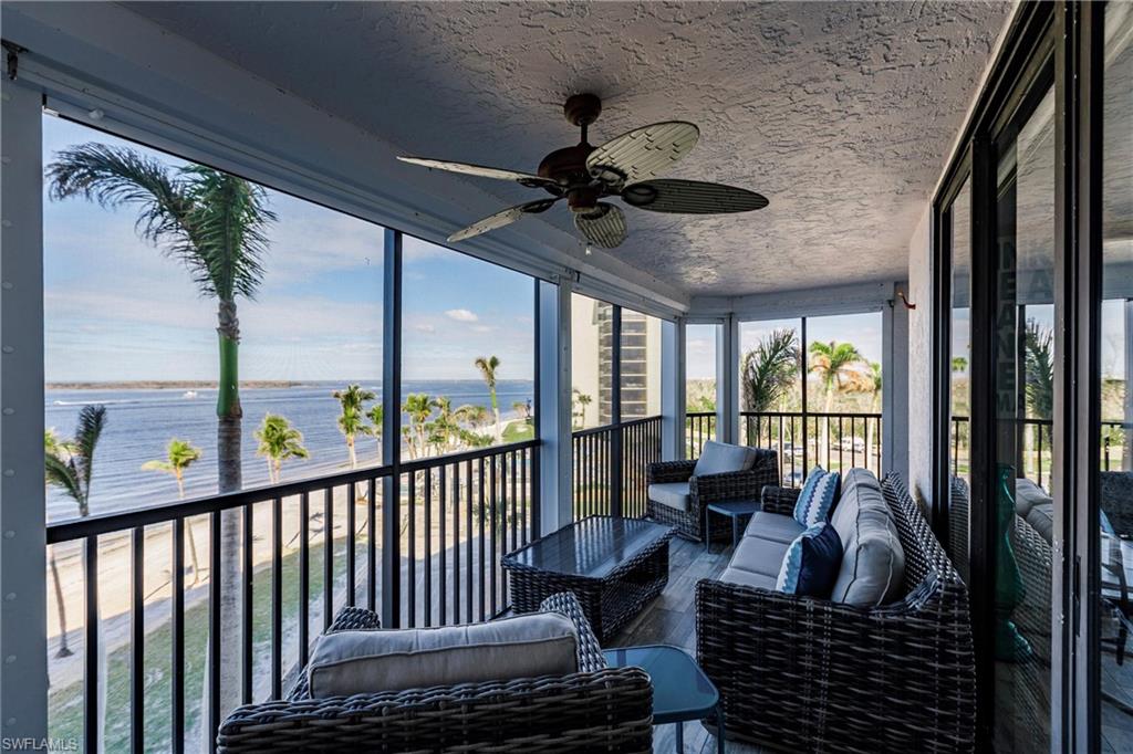 Sunroom featuring ceiling fan and a water view
