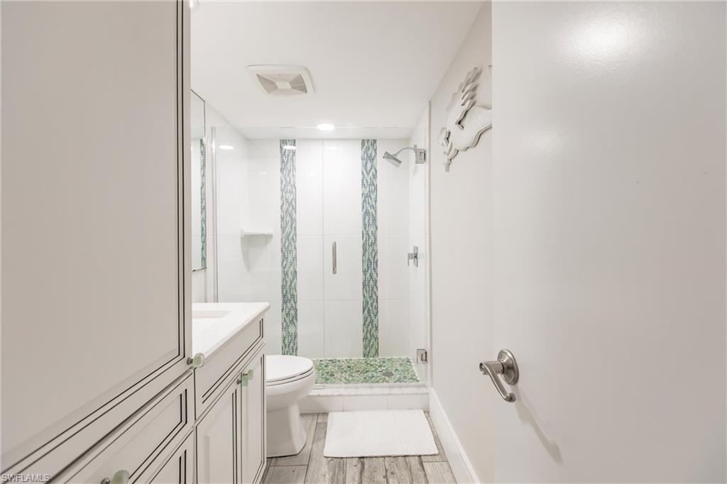 Bathroom with vanity, toilet, and an enclosed shower