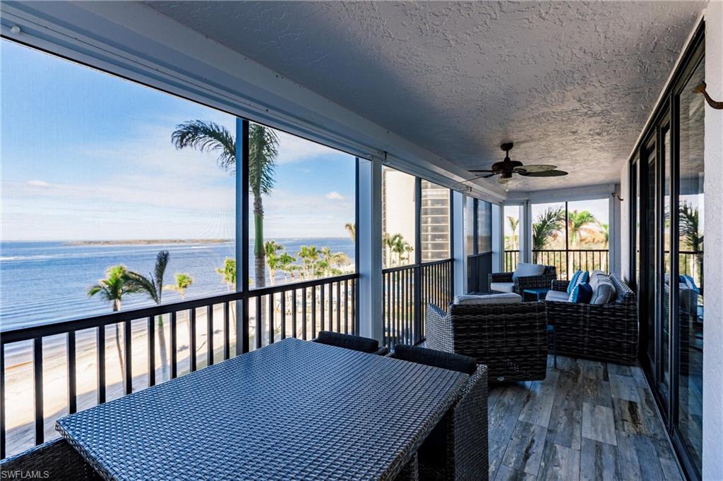 Sunroom with ceiling fan and a water view