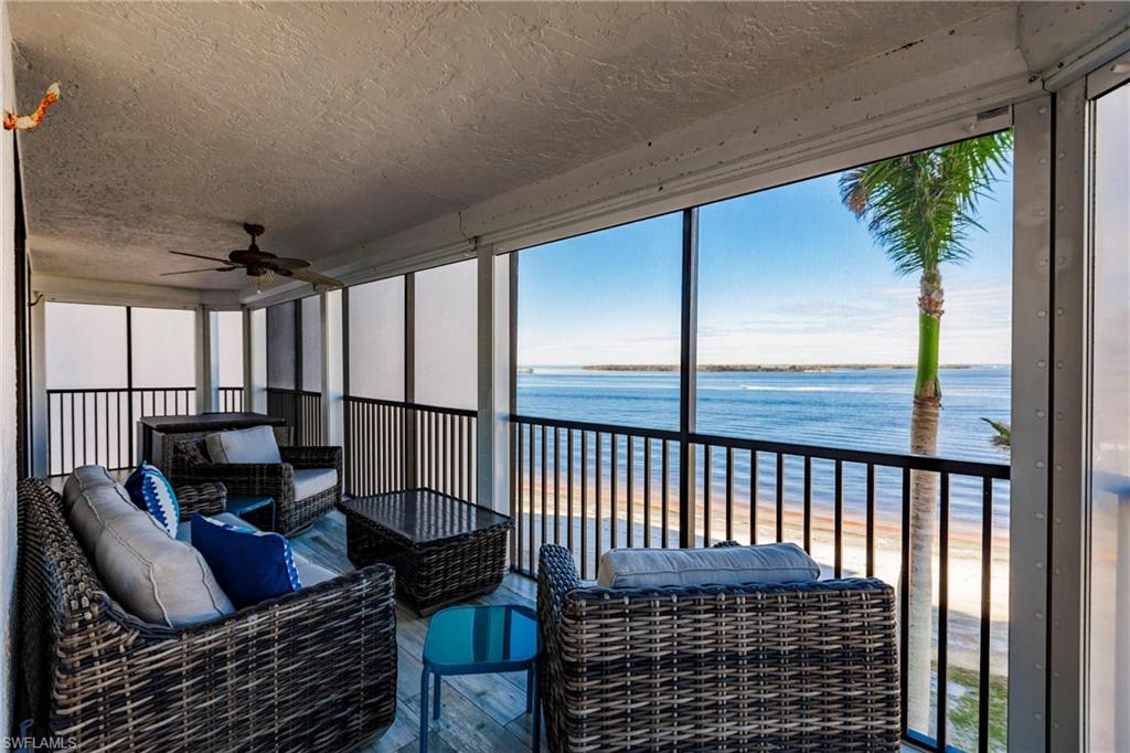 Sunroom / solarium with ceiling fan, a water view, and a view of the beach