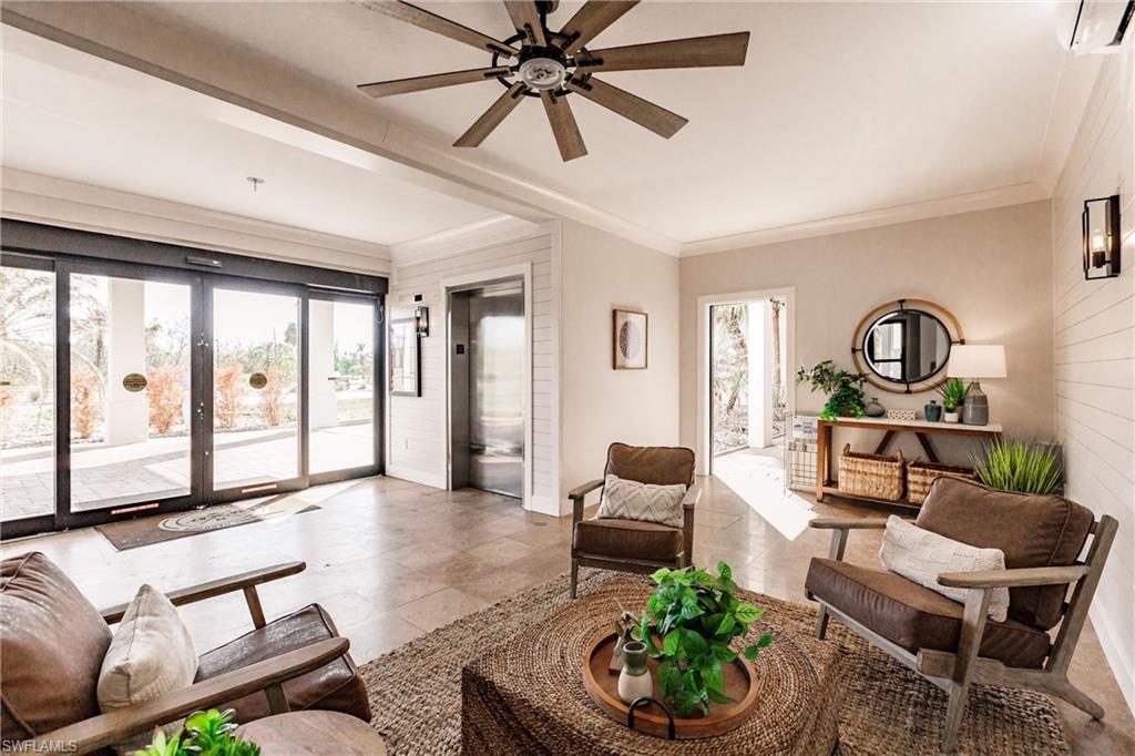Living room with french doors, crown molding, elevator, ceiling fan, and a wall mounted AC