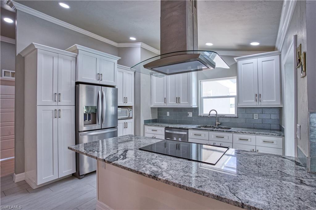Beautifully remodeled kitchen with white wood cabinets, granite countertops, stainless appliances.