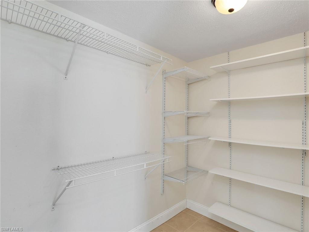 Spacious closet featuring light tile patterned flooring
