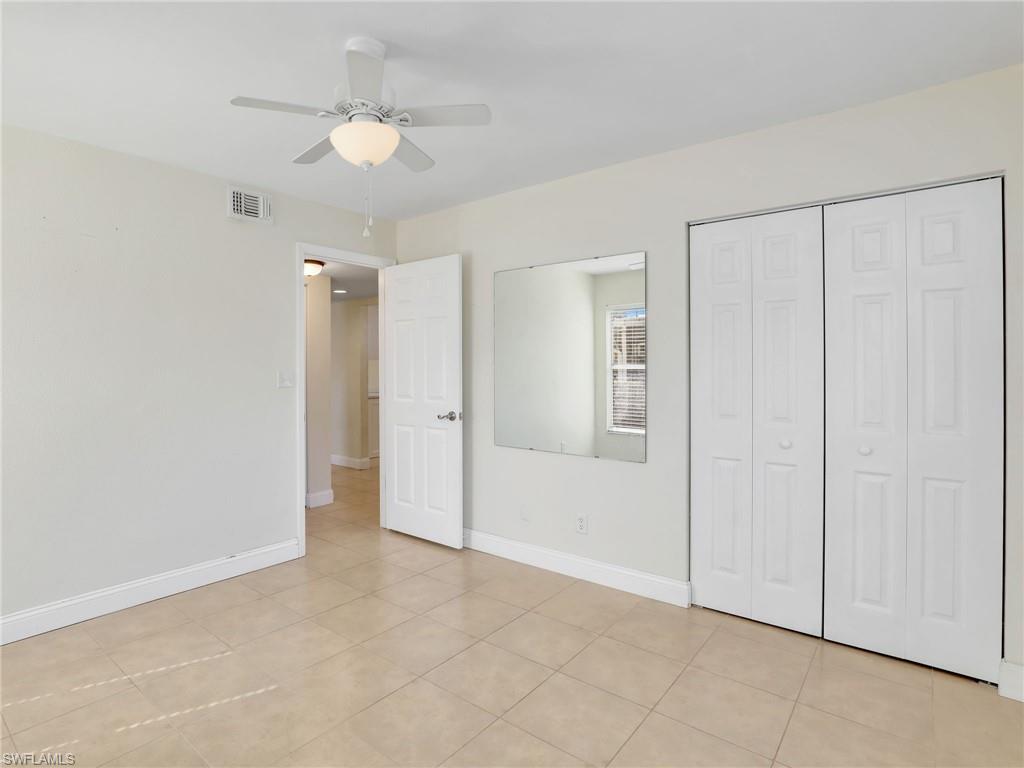 Unfurnished bedroom with ceiling fan, a closet, and light tile patterned floors