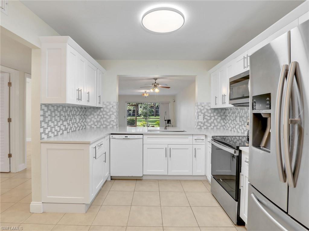 Kitchen featuring white cabinets, appliances with stainless steel finishes, and tasteful backsplash