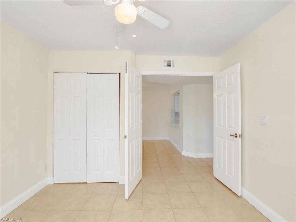 Unfurnished bedroom featuring a closet, ceiling fan, and light tile patterned flooring