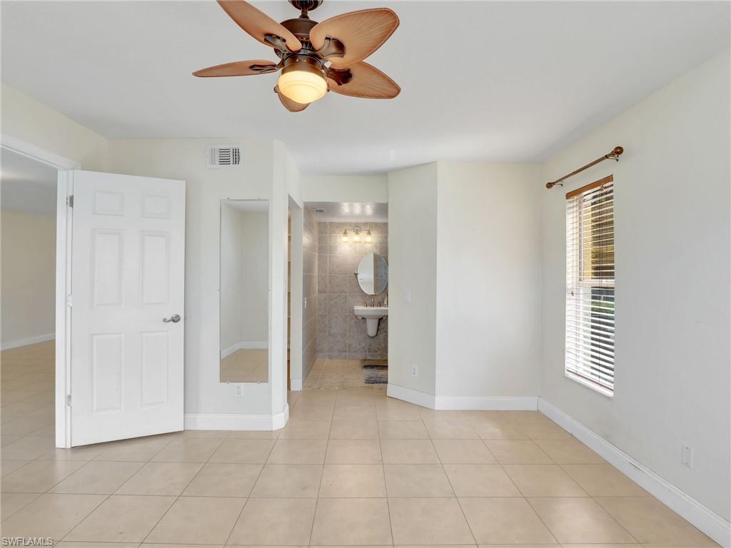 Tiled spare room with ceiling fan