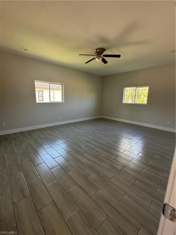 Spare room featuring ceiling fan, a healthy amount of sunlight, and hardwood / wood-style flooring